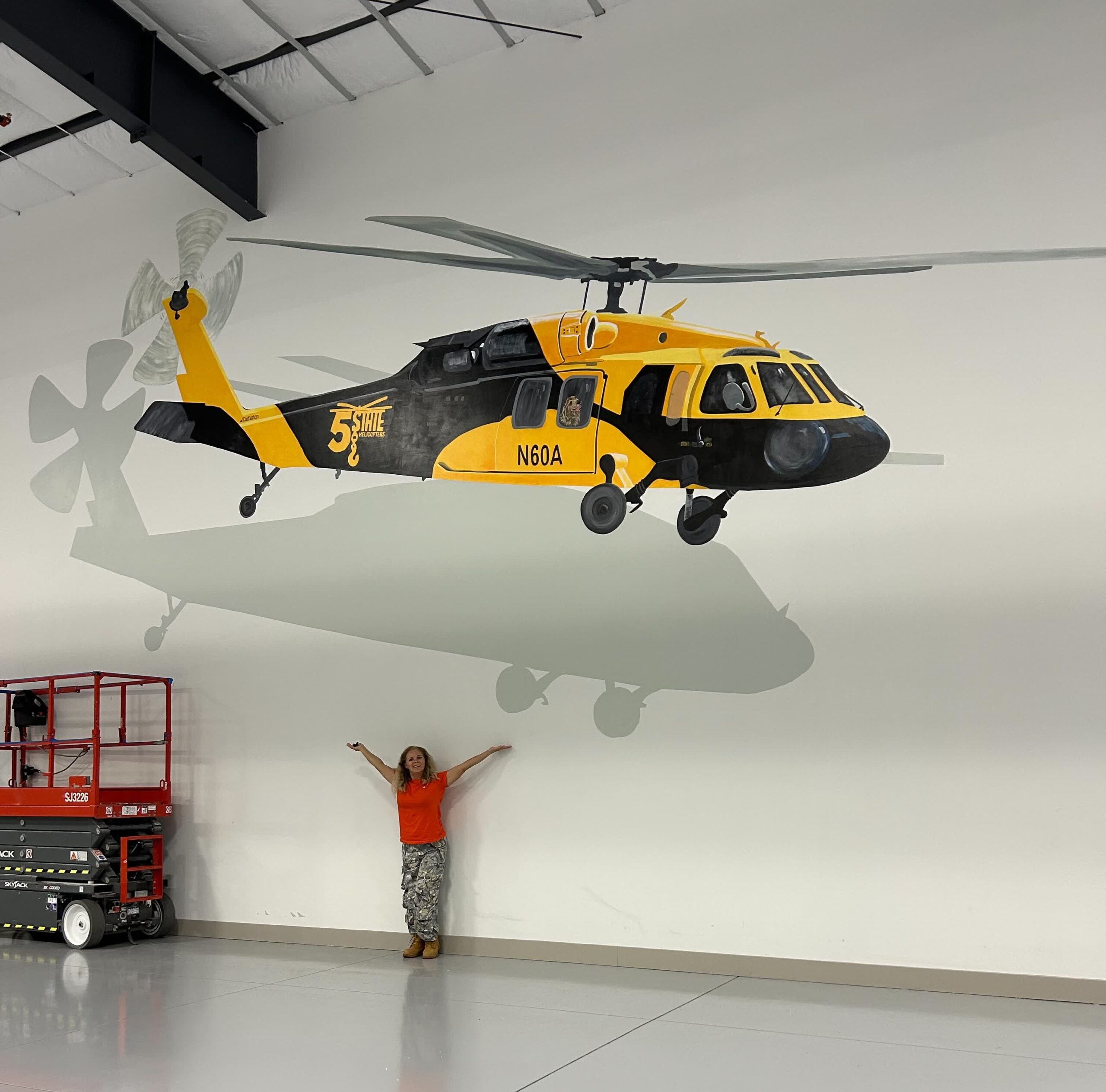 Person posing under helicopter wall mural
