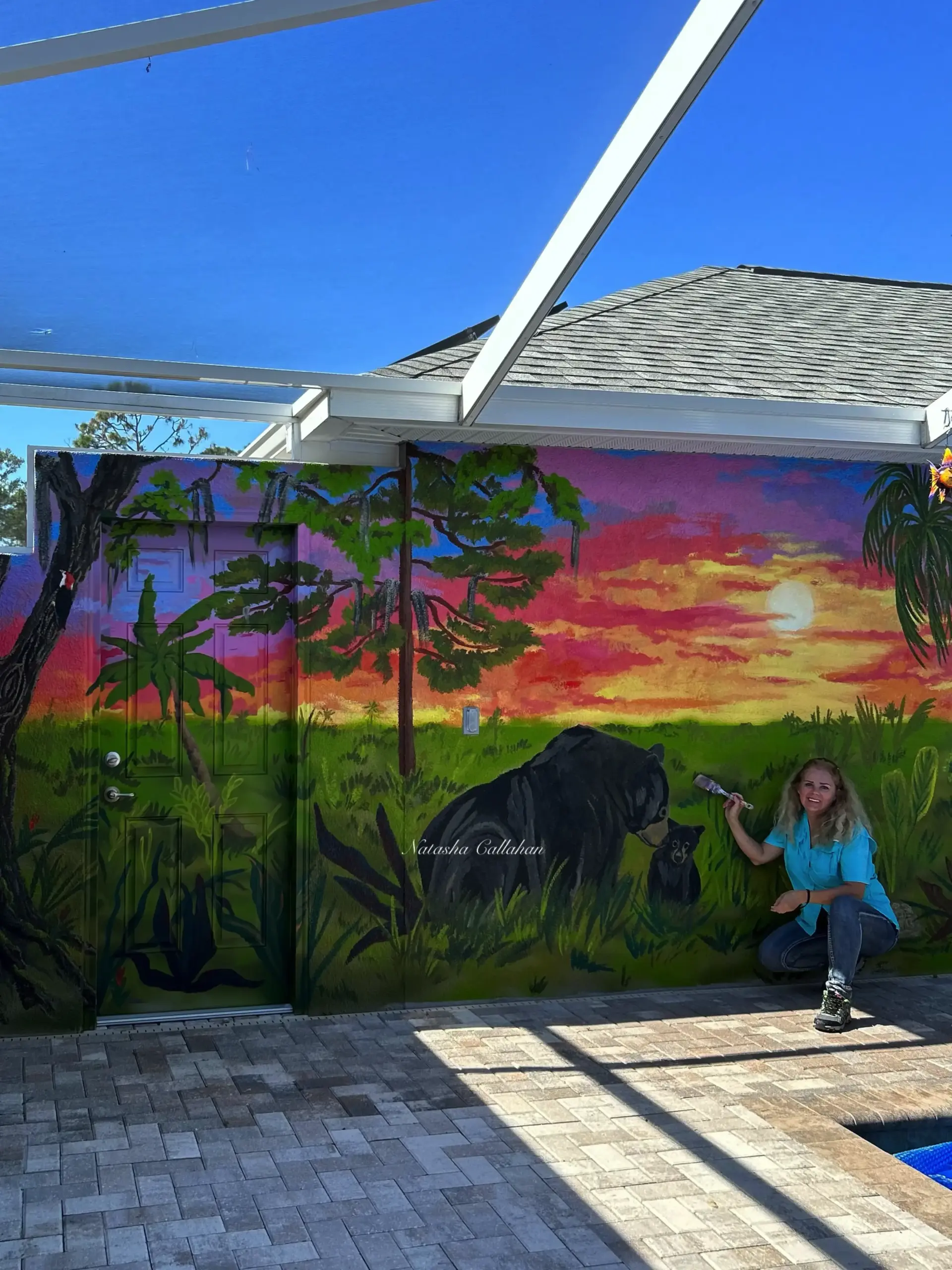 Artist painting colorful nature mural with bears at sunset