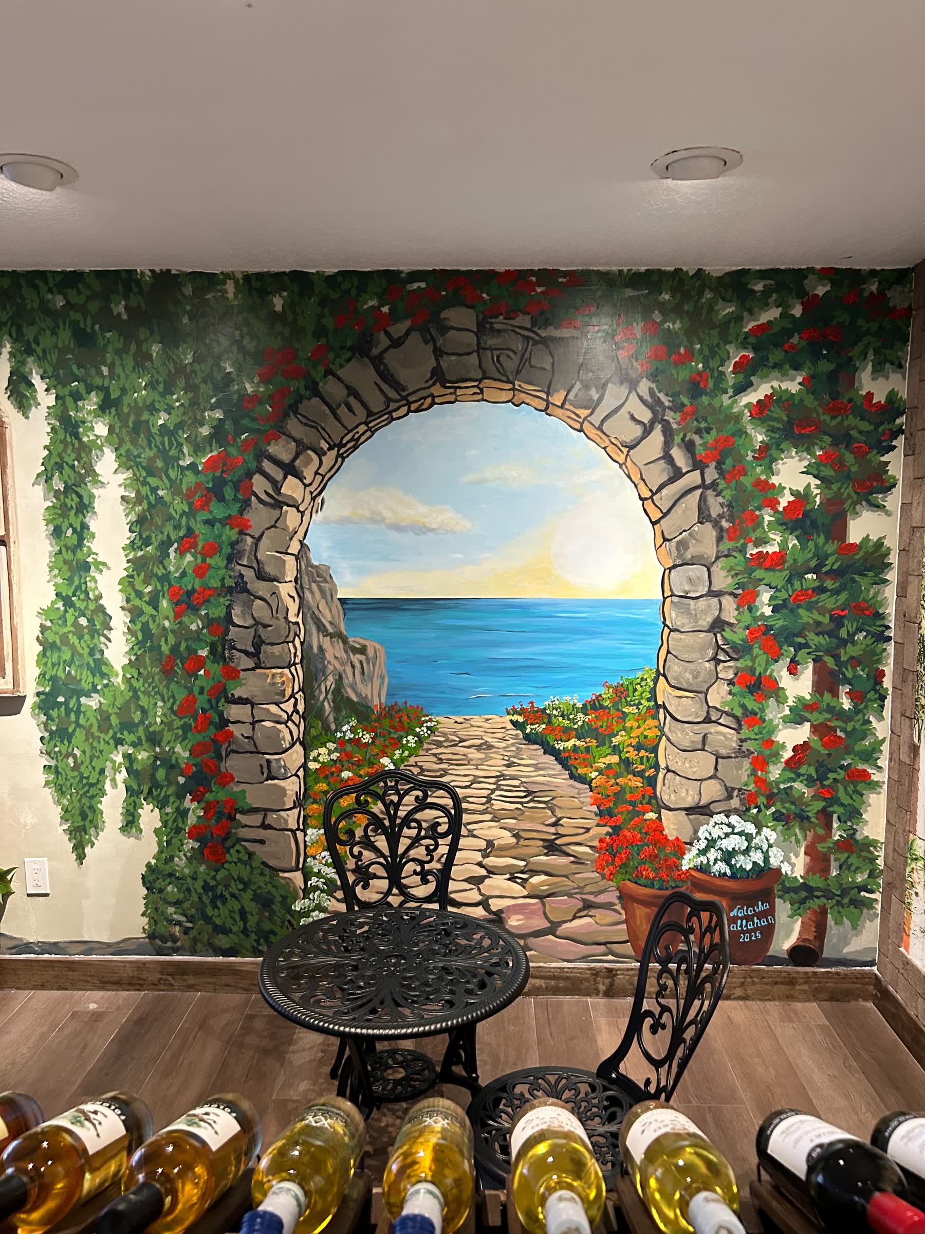 Mural of seaside archway with flowers and sunset