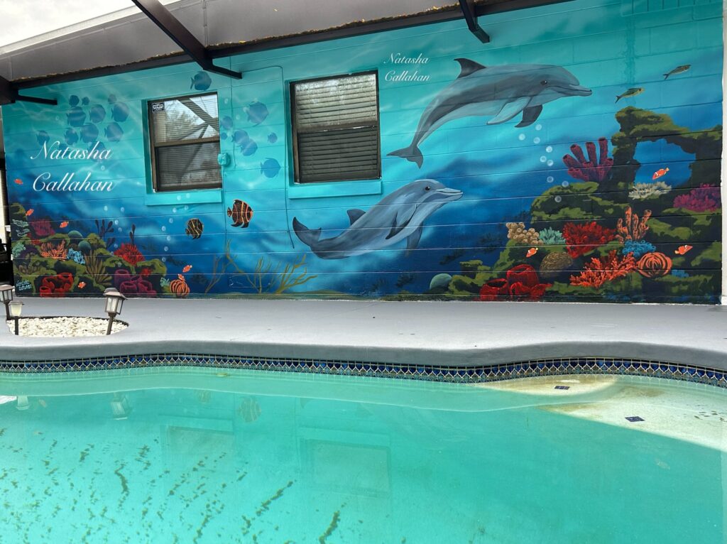 Underwater mural with dolphins and coral reef.