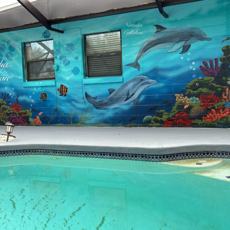 Underwater mural with dolphins and coral reef.